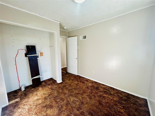 unfurnished bedroom with carpet flooring, visible vents, and ornamental molding