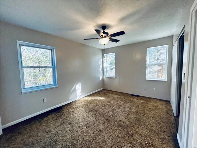 unfurnished bedroom featuring carpet flooring, a ceiling fan, baseboards, and a textured ceiling