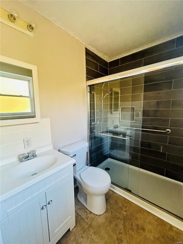 full bathroom featuring vanity, a stall shower, decorative backsplash, tile patterned flooring, and toilet