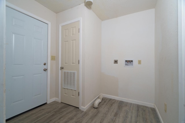 clothes washing area featuring hookup for an electric dryer, hardwood / wood-style floors, a textured ceiling, and hookup for a washing machine