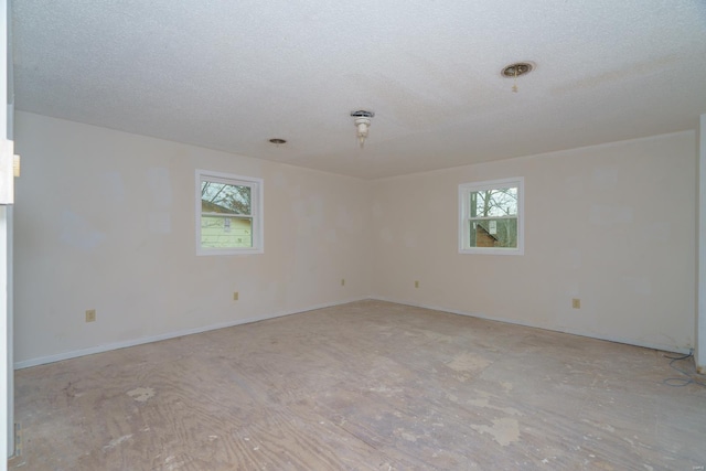 empty room featuring plenty of natural light and a textured ceiling