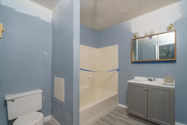 full bathroom featuring a textured ceiling, toilet, vanity, bathtub / shower combination, and hardwood / wood-style flooring