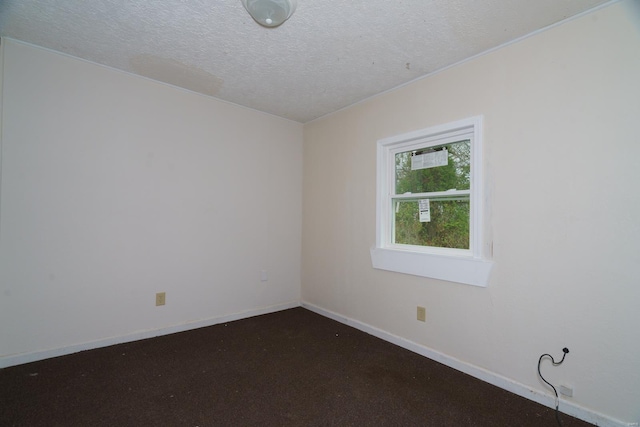 carpeted empty room with a textured ceiling