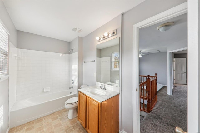 full bathroom with vanity, ceiling fan, toilet, and tiled shower / bath combo