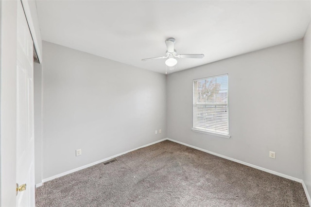 empty room with ceiling fan and carpet floors