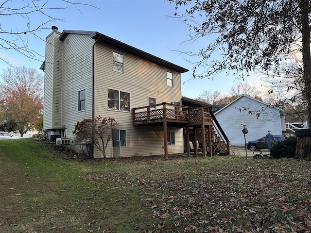 back of property featuring a wooden deck and a yard