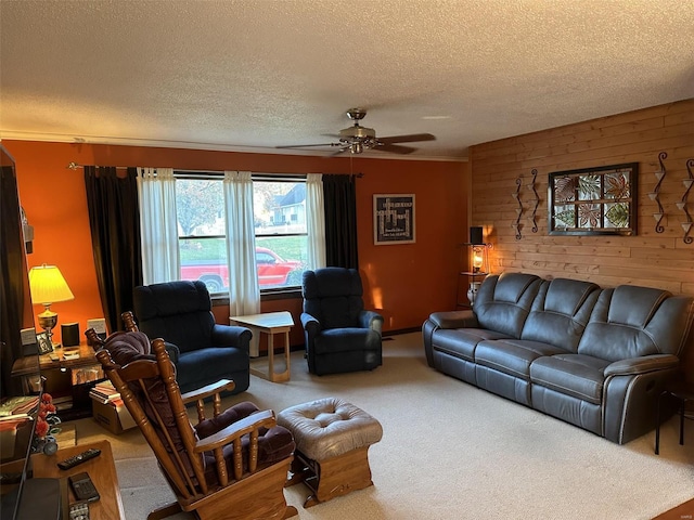 living room featuring a textured ceiling, carpet floors, ceiling fan, and wooden walls