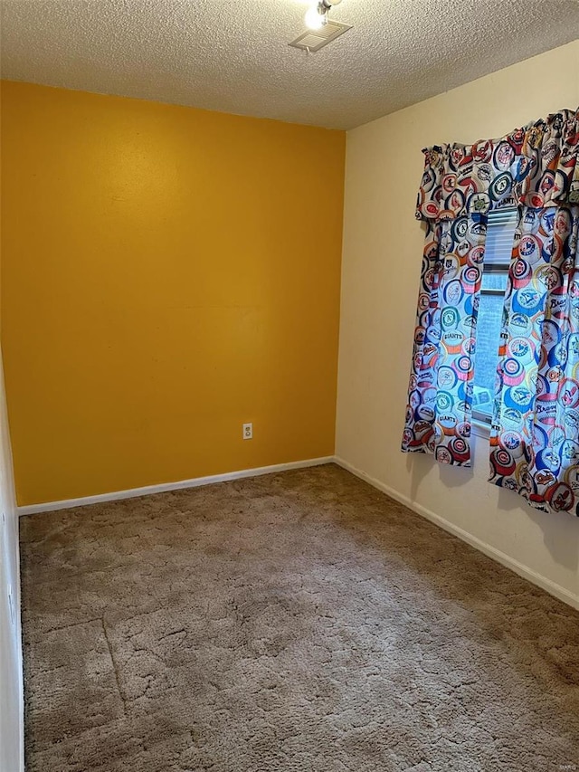 carpeted spare room with a textured ceiling