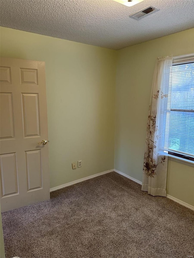 carpeted spare room featuring a textured ceiling