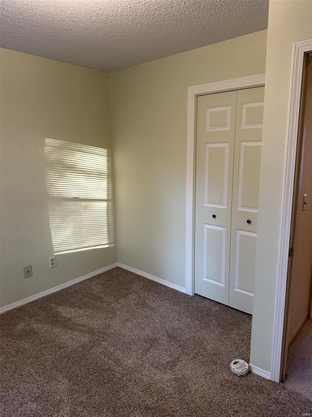 spare room featuring carpet and a textured ceiling