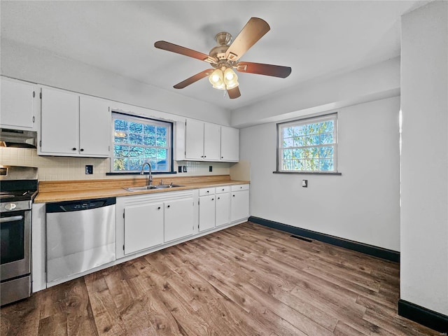 kitchen featuring a wealth of natural light, white cabinetry, and appliances with stainless steel finishes