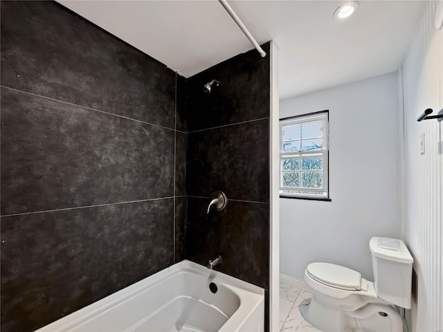 bathroom with tiled shower / bath combo and toilet