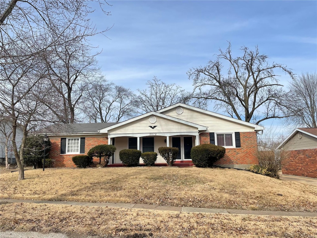 ranch-style house with a front yard and a porch