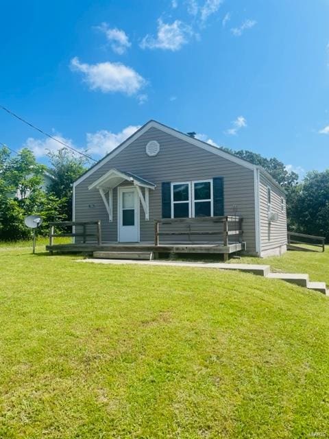 rear view of house with a wooden deck and a yard