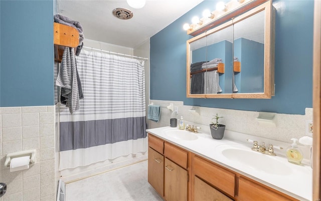 bathroom with vanity and tile walls