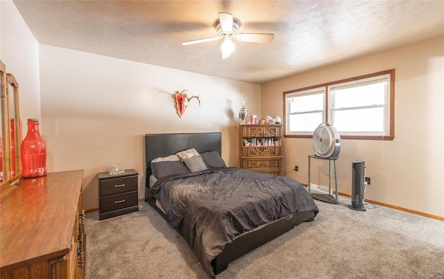 bedroom featuring a textured ceiling, light colored carpet, and ceiling fan