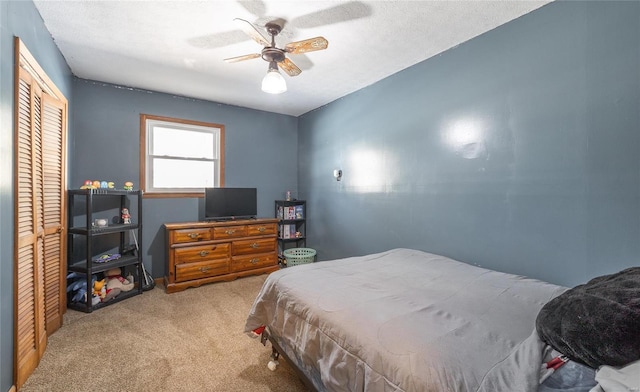 bedroom featuring carpet flooring, a textured ceiling, a closet, and ceiling fan