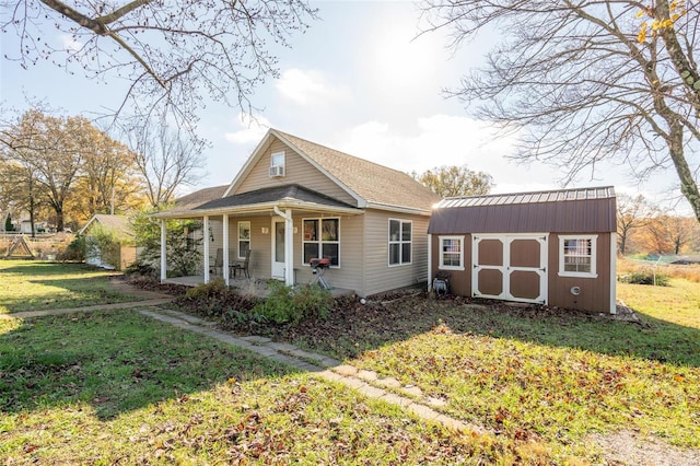 bungalow-style home with covered porch, a shed, and a front lawn