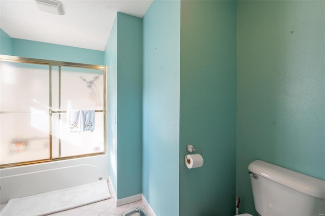 bathroom with tile patterned flooring, bath / shower combo with glass door, and toilet