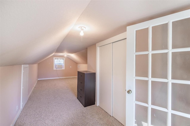 bonus room with lofted ceiling, light carpet, and a textured ceiling