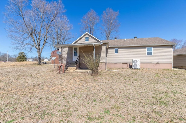 rear view of property featuring ac unit, covered porch, and a yard