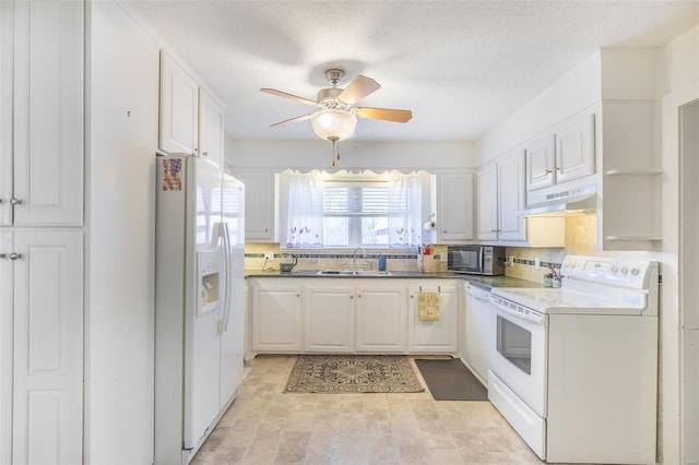 kitchen featuring white appliances, a sink, white cabinetry, and under cabinet range hood