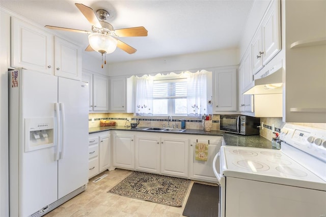 kitchen featuring dark countertops, white cabinetry, a sink, white appliances, and under cabinet range hood