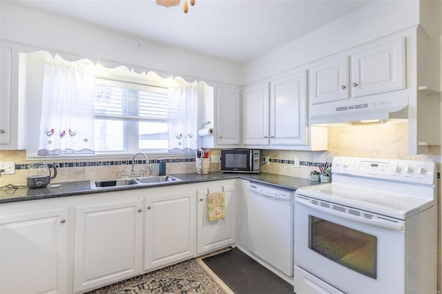 kitchen with white appliances, tasteful backsplash, white cabinets, under cabinet range hood, and a sink