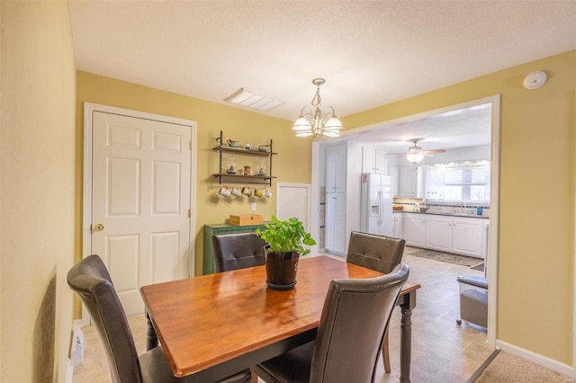 dining area with baseboards, visible vents, a textured ceiling, and ceiling fan with notable chandelier