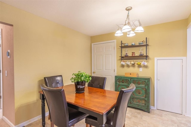 dining room featuring baseboards and a notable chandelier