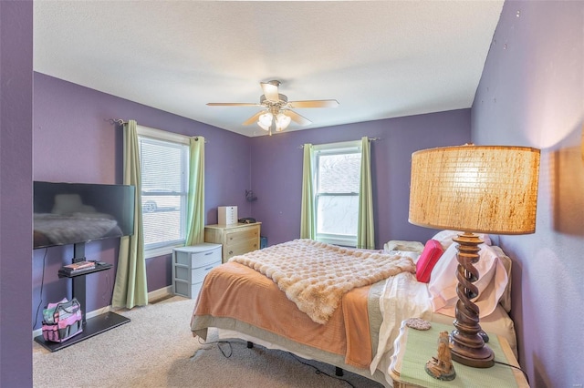 carpeted bedroom with a textured ceiling, a ceiling fan, and baseboards