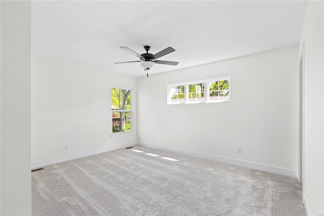 spare room with ceiling fan and light carpet