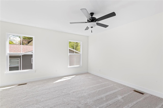 carpeted empty room with ceiling fan and a healthy amount of sunlight