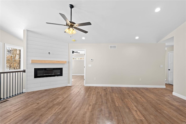 unfurnished living room with lofted ceiling, a fireplace, ceiling fan, and light hardwood / wood-style floors