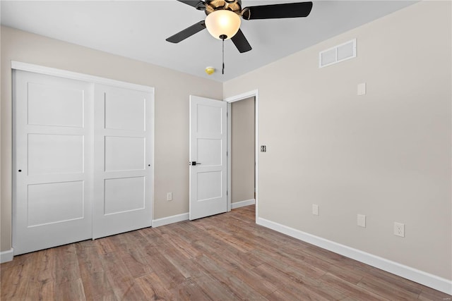 unfurnished bedroom with ceiling fan, light hardwood / wood-style floors, and a closet