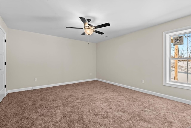 carpeted spare room featuring ceiling fan