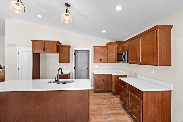 kitchen featuring decorative light fixtures, lofted ceiling, and sink