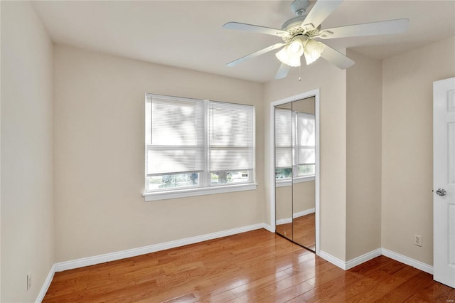 unfurnished bedroom featuring wood-type flooring, a closet, and ceiling fan