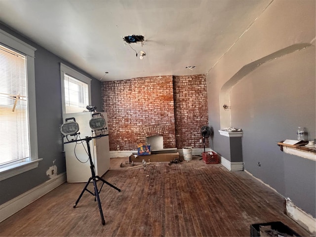 workout area with wood-type flooring and brick wall