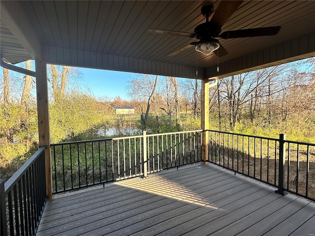 wooden terrace featuring ceiling fan and a water view