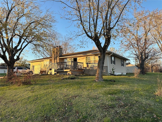 rear view of house with a yard and a wooden deck