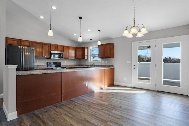 kitchen featuring sink, decorative light fixtures, kitchen peninsula, and appliances with stainless steel finishes