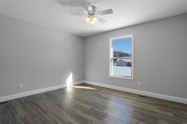 empty room with ceiling fan and dark hardwood / wood-style floors