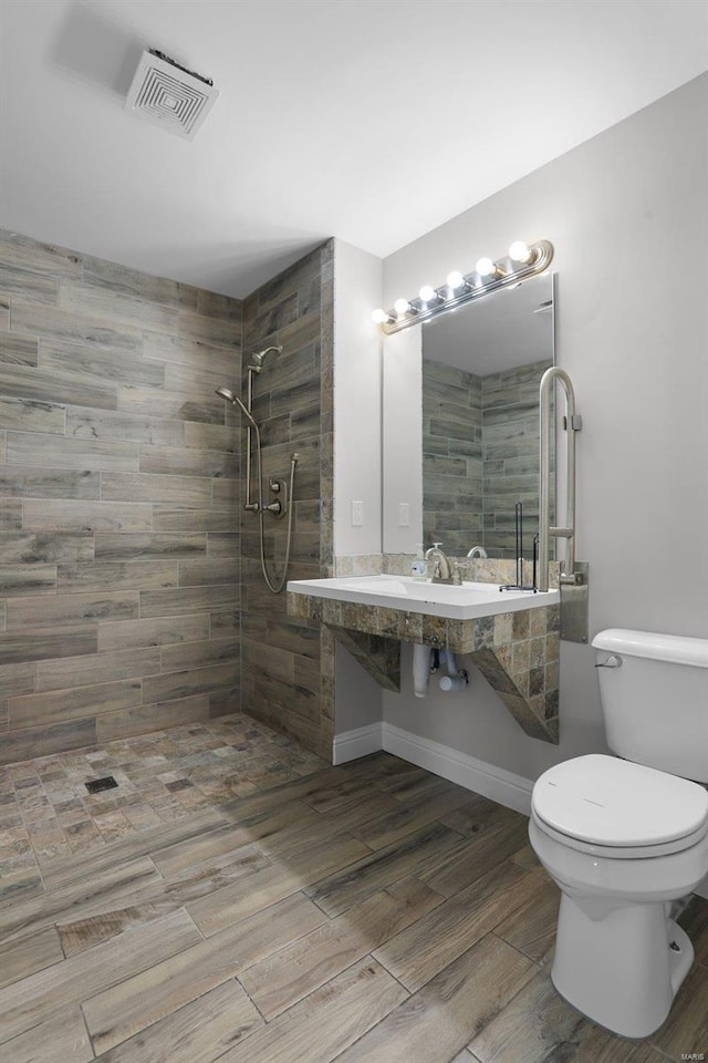 bathroom featuring toilet and a tile shower