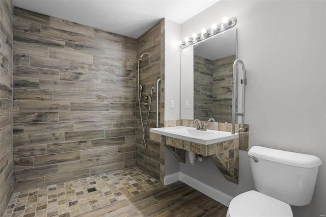 bathroom featuring toilet and a tile shower