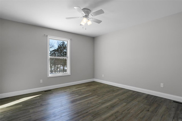 spare room with dark wood-type flooring and ceiling fan