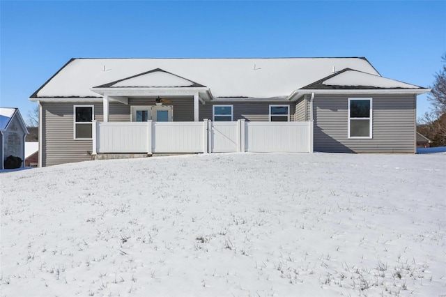 snow covered rear of property with ceiling fan