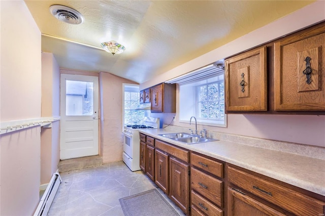 kitchen featuring white gas range, sink, lofted ceiling, and a baseboard heating unit