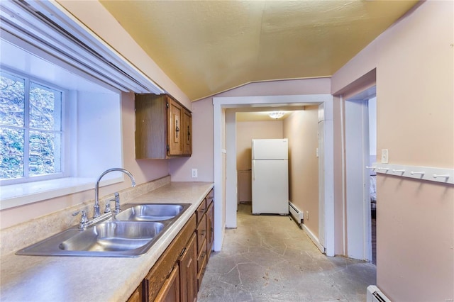 kitchen featuring vaulted ceiling, sink, a baseboard heating unit, and white refrigerator