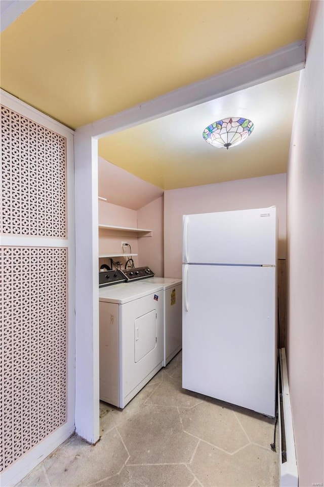 washroom with washing machine and clothes dryer and a baseboard heating unit